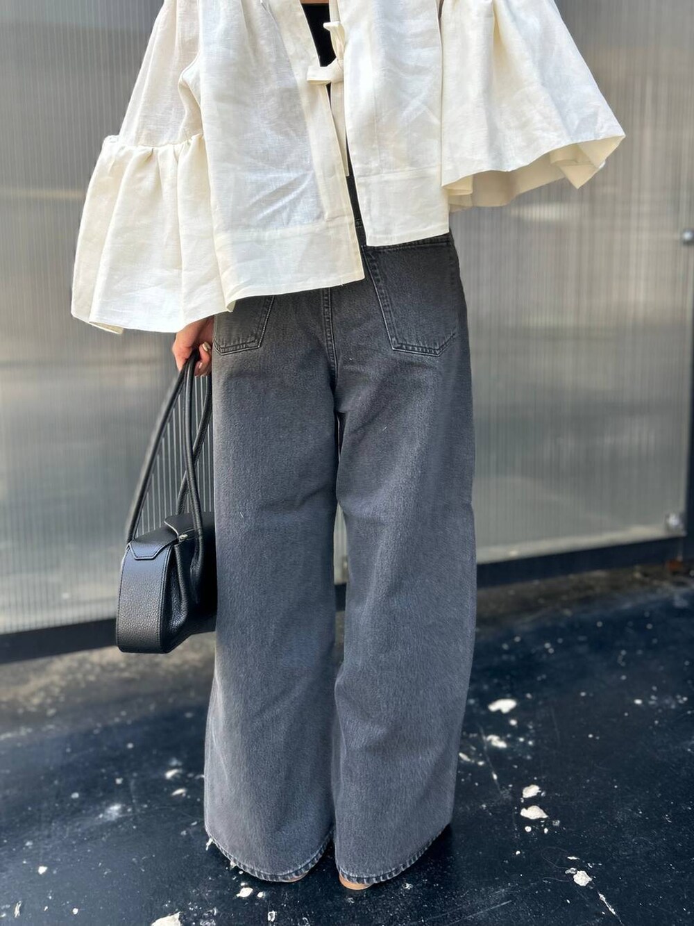 ブラック系のチューブトップ、ホワイト系のシャツ/ブラウス、ブラック系のデニムパンツを着用したレディースの春コーディネートの9枚目の写真