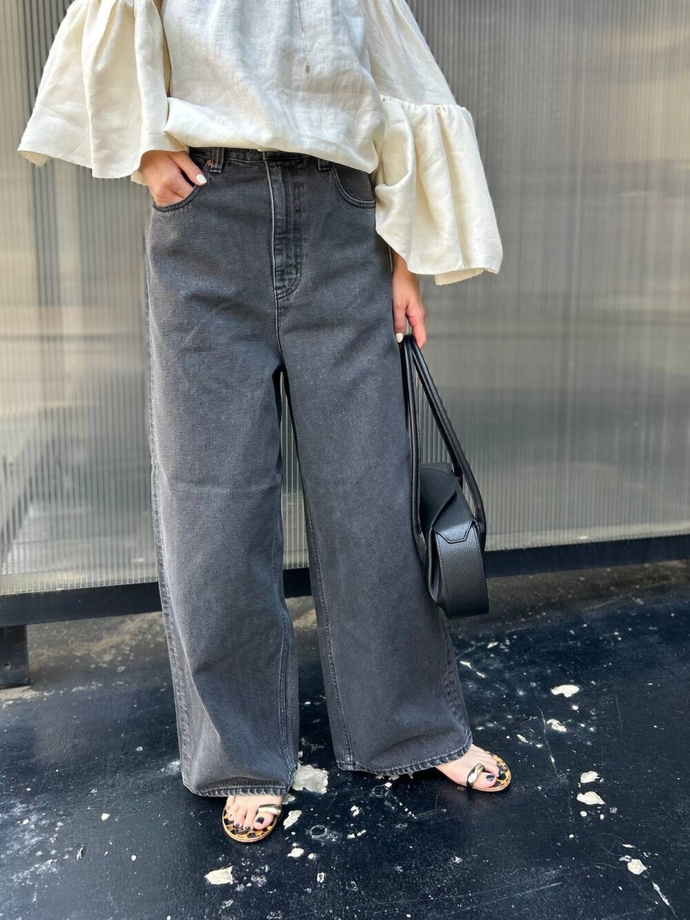 ブラック系のチューブトップ、ホワイト系のシャツ/ブラウス、ブラック系のデニムパンツを着用したレディースの春コーディネートの8枚目の写真