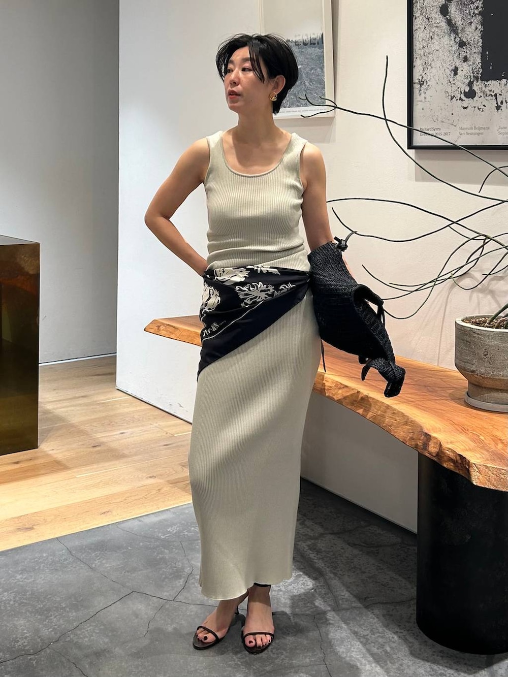 グレー系のタンクトップ、ブラック系のブルゾン、グレー系のスカートを着用したレディースの春コーディネートの3枚目の写真