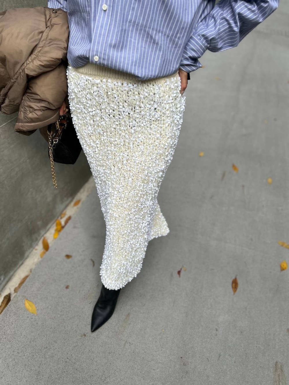 ブラック系のニット/セーター、ブルー系のシャツ/ブラウス、ブラウン系のダウンジャケット/コートを着用したレディースの冬コーディネートの8枚目の写真