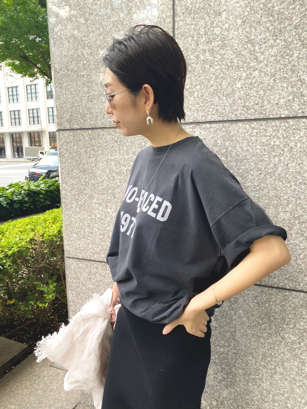 ブラック系のTシャツ/カットソー、ブラック系のスカート、ベージュ系のストール/ショールを着用したレディースの春コーディネートの4枚目の写真