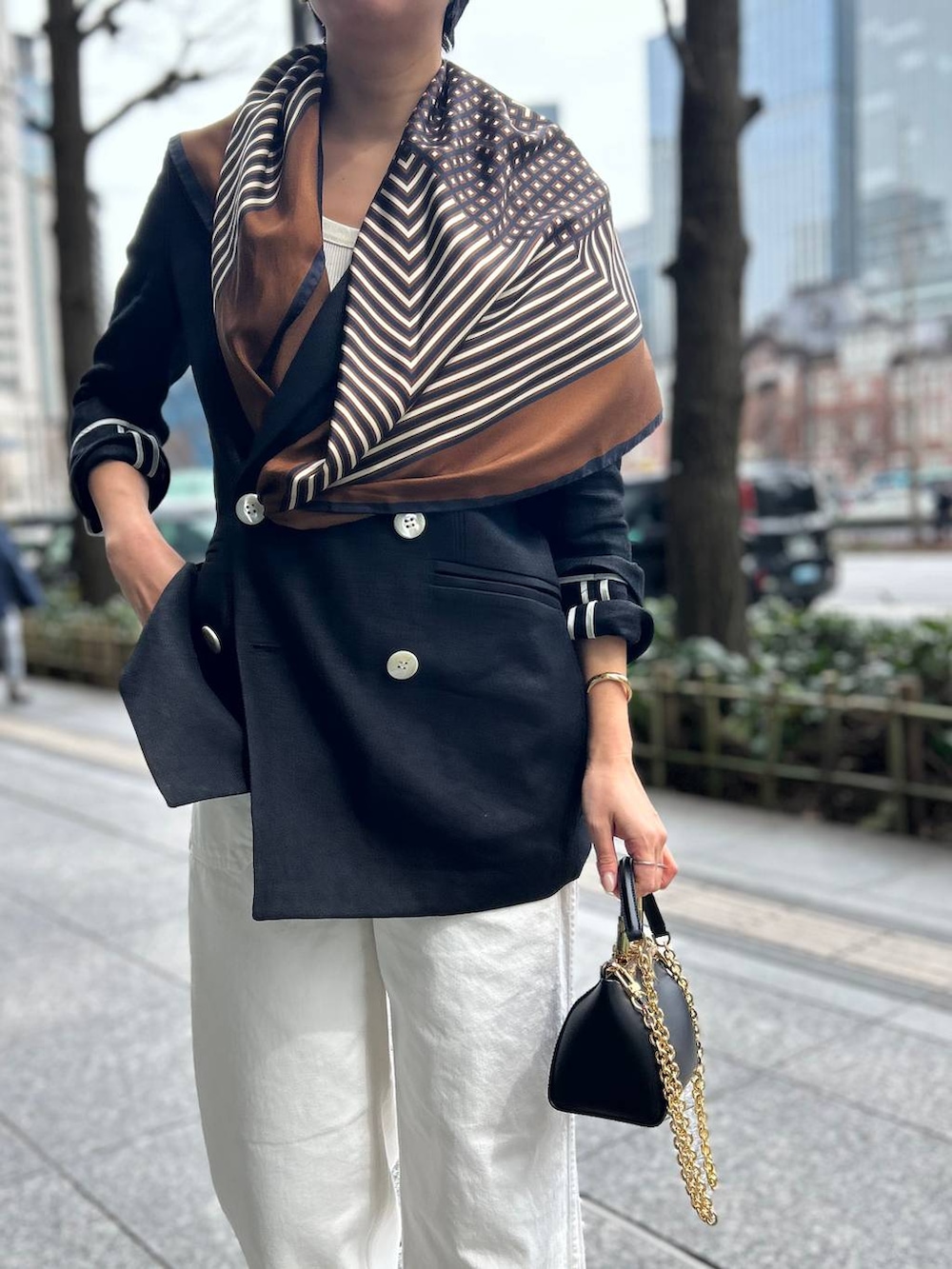 ホワイト系のデニムパンツ、ホワイト系のタンクトップ、ブラック系のテーラードジャケットを着用したレディースの春コーディネートの8枚目の写真