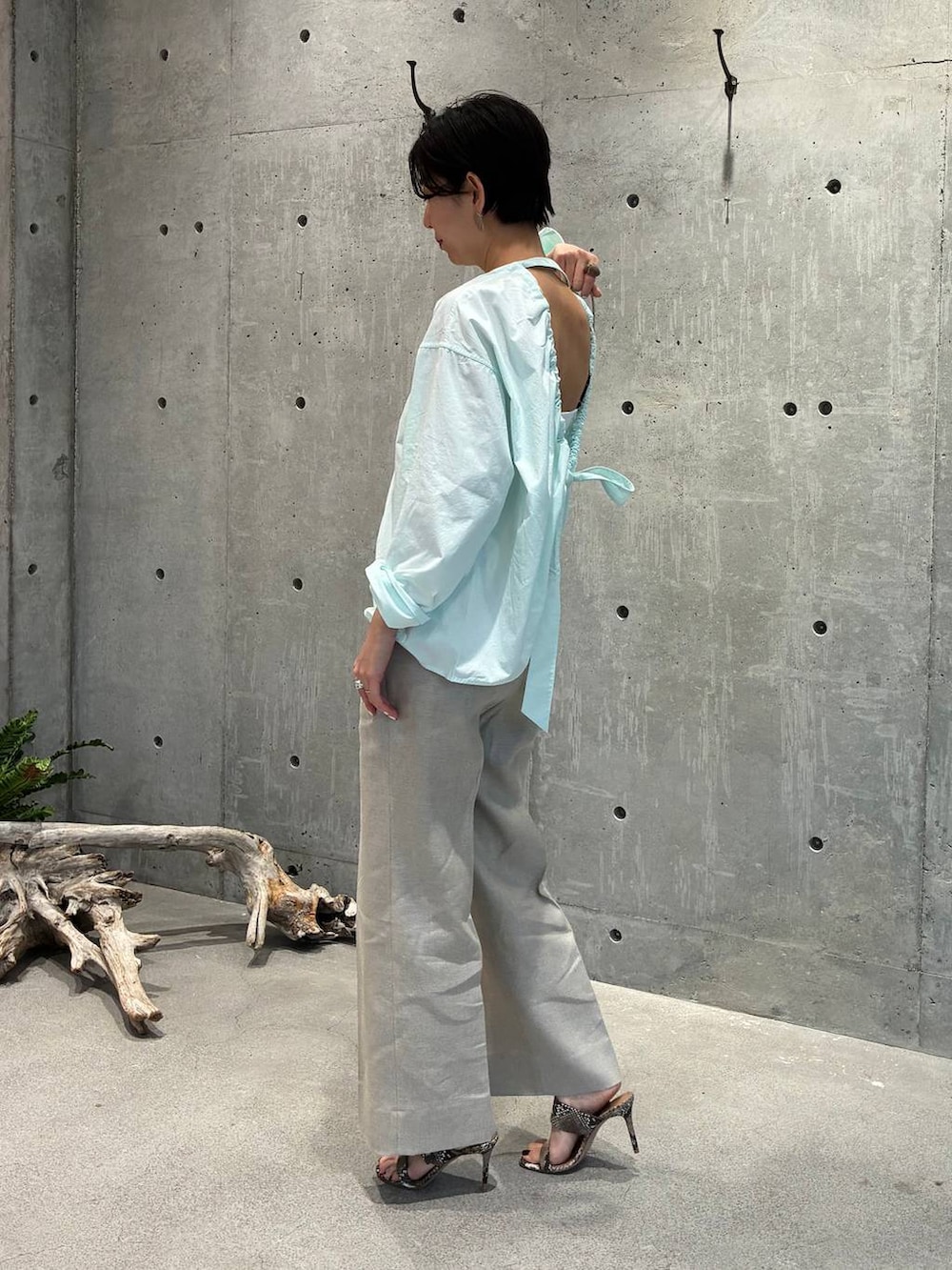 ホワイト系のスラックス、グレー系のナイロンジャケットを着用したレディースの春コーディネートの5枚目の写真