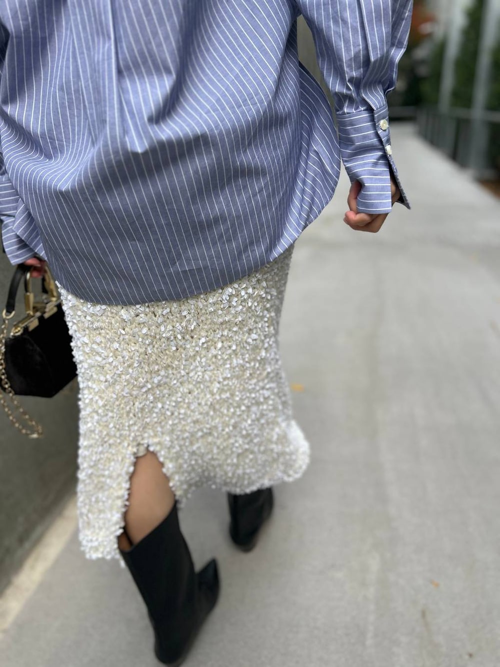 ブラック系のニット/セーター、ブルー系のシャツ/ブラウス、ブラウン系のダウンジャケット/コートを着用したレディースの冬コーディネートの9枚目の写真