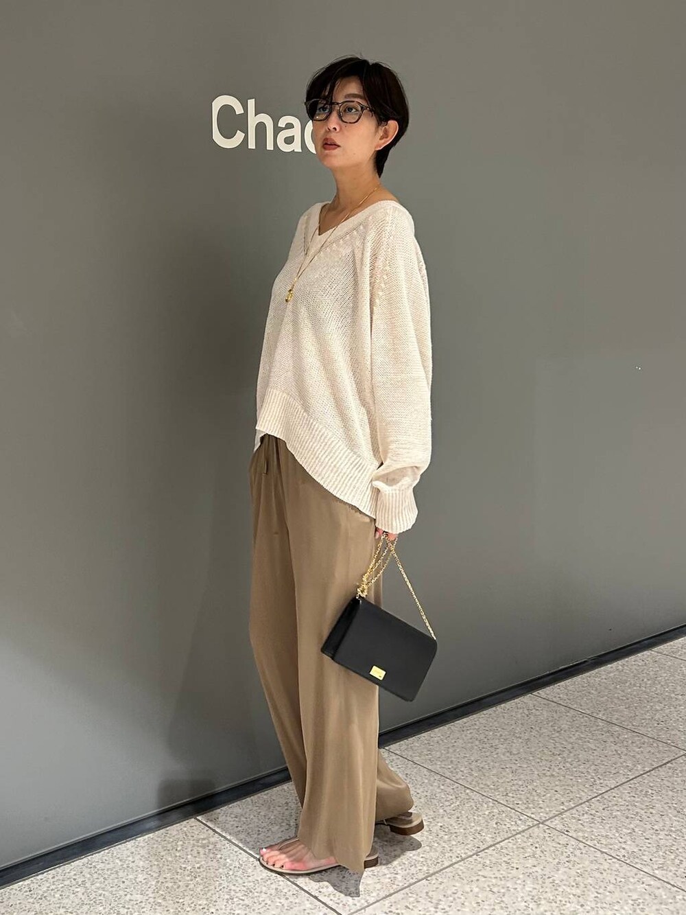 ベージュ系のその他パンツ、ホワイト系のニット/セーターを着用したレディースの夏コーディネートの3枚目の写真