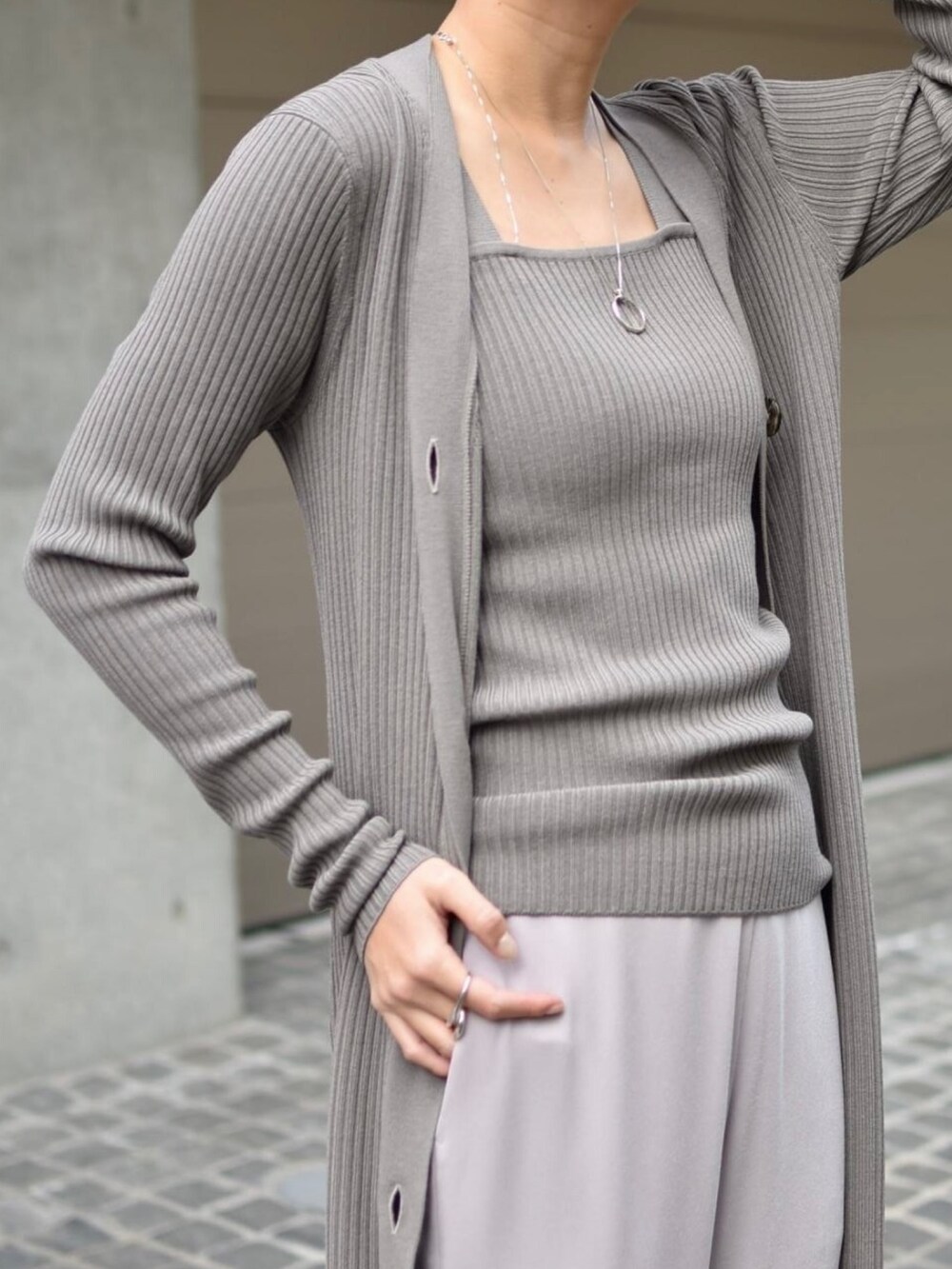 グレー系のタンクトップ、ピンク系のスラックス、グレー系のカーディガン/ボレロを着用したレディースの冬コーディネートの4枚目の写真