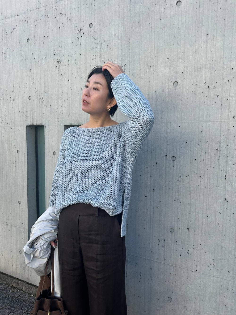 ブルー系のニット/セーター、ホワイト系のその他トップス、グレー系のナイロンジャケットを着用したレディースの冬コーディネートの6枚目の写真