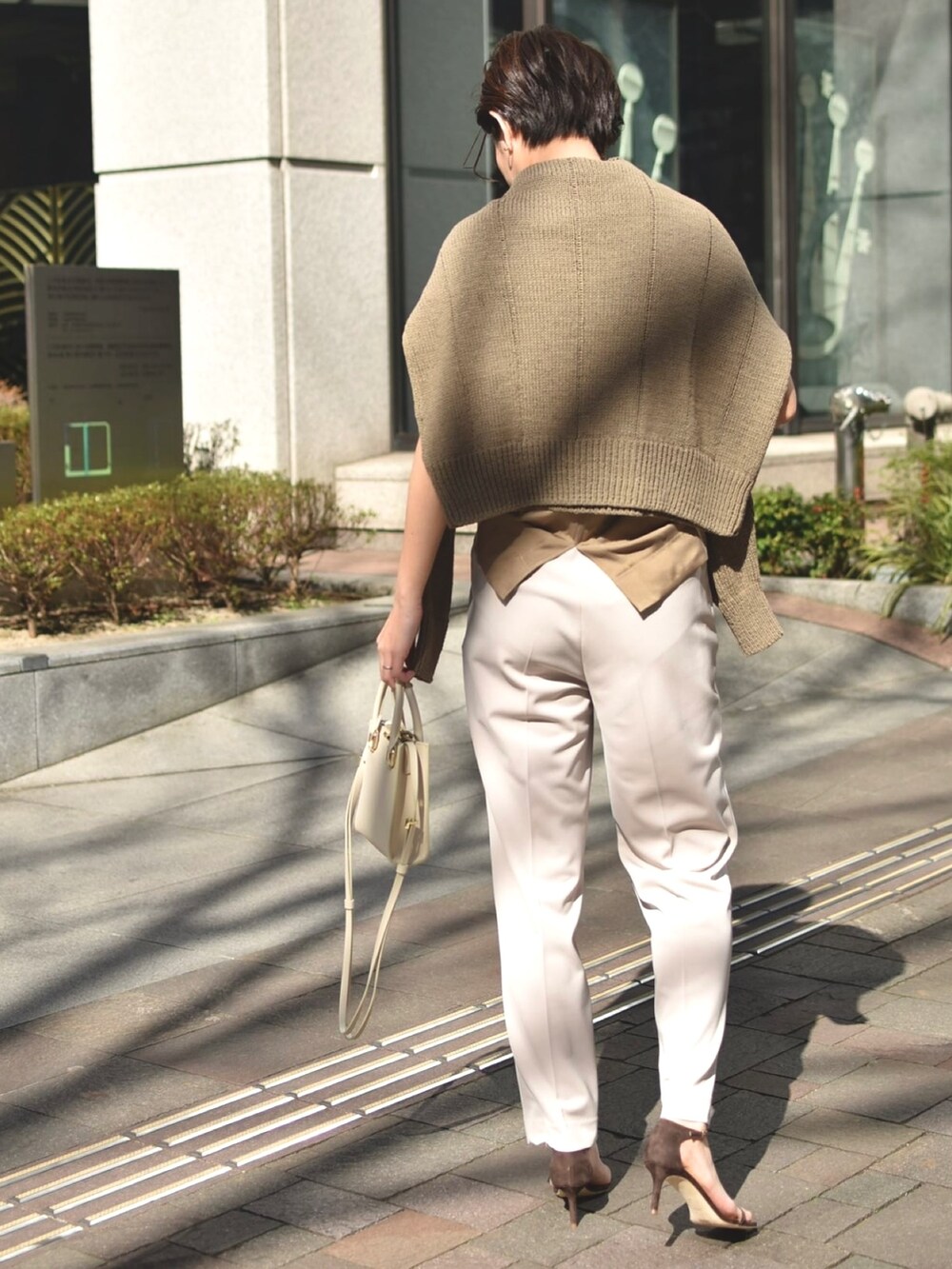 ブラウン系のニット/セーター、ブラウン系のTシャツ/カットソー、ベージュ系のパンツを着用したレディースの春コーディネートの3枚目の写真