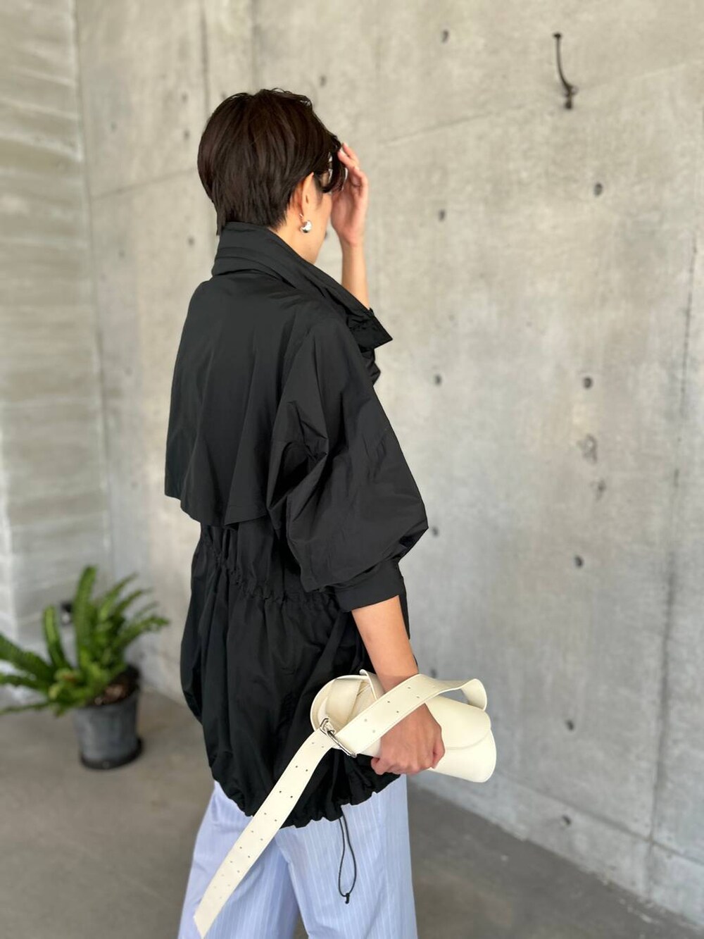 ブラック系のタンクトップ、ブルー系のその他パンツ、ブラック系のブルゾンを着用したレディースの夏コーディネートの7枚目の写真