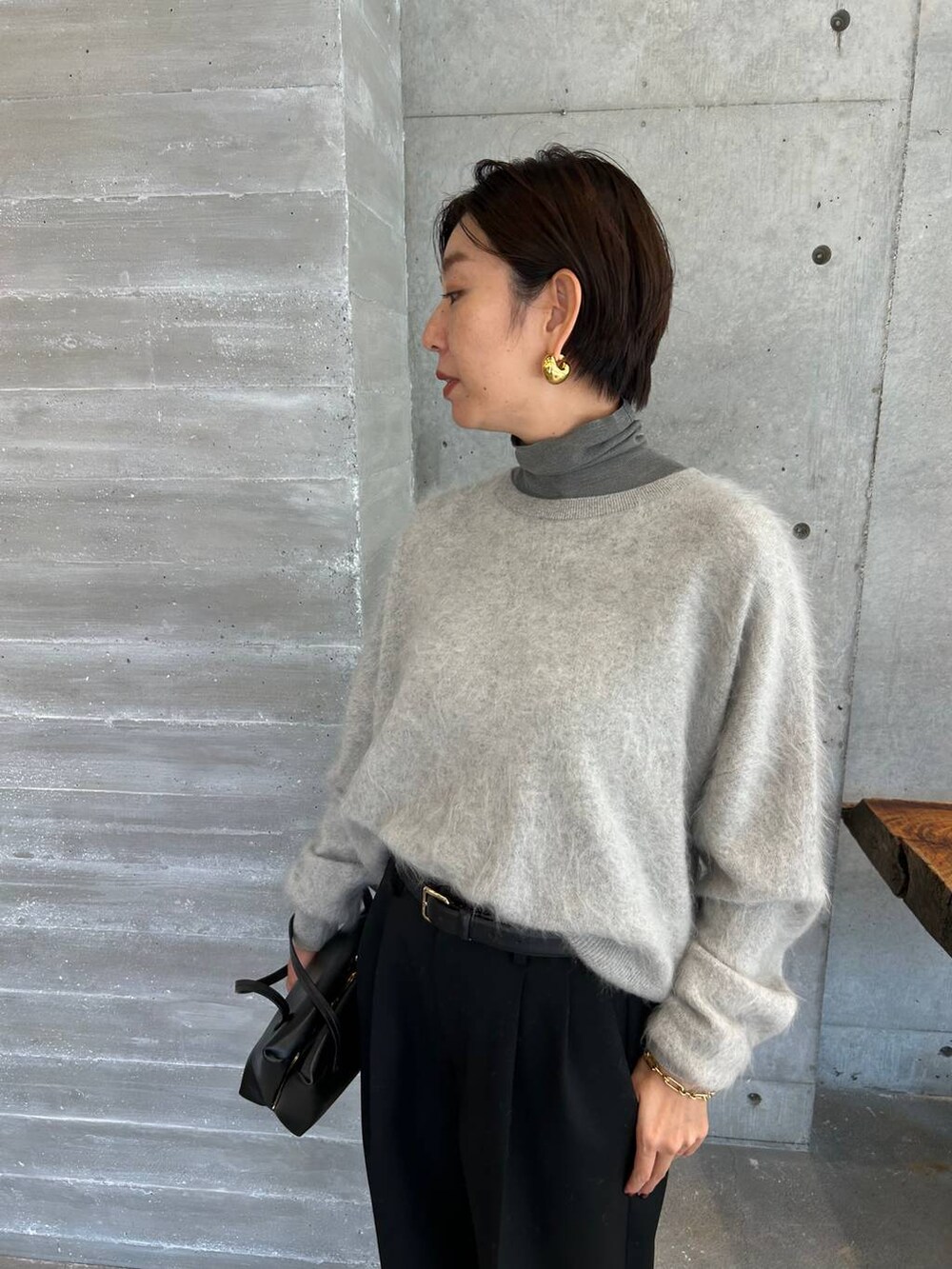 ピンク系のノーカラーコート、グレー系のニット/セーター、ブラック系のベルトを着用したレディースの秋コーディネートの8枚目の写真