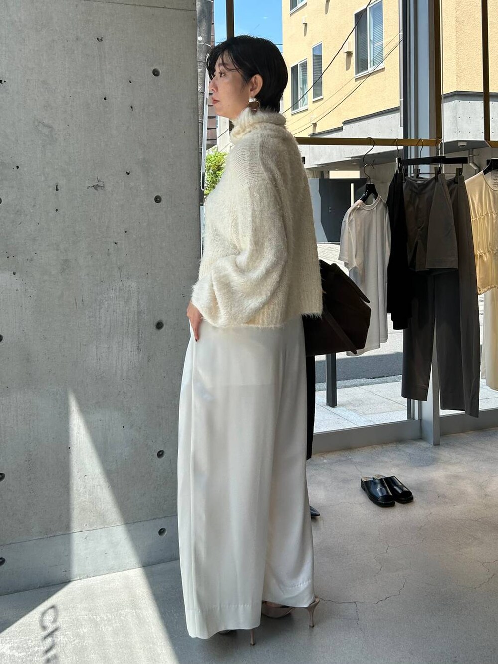 ホワイト系のニット/セーター、ホワイト系のその他パンツ、ブラウン系のピーコートを着用したレディースの秋コーディネートの4枚目の写真