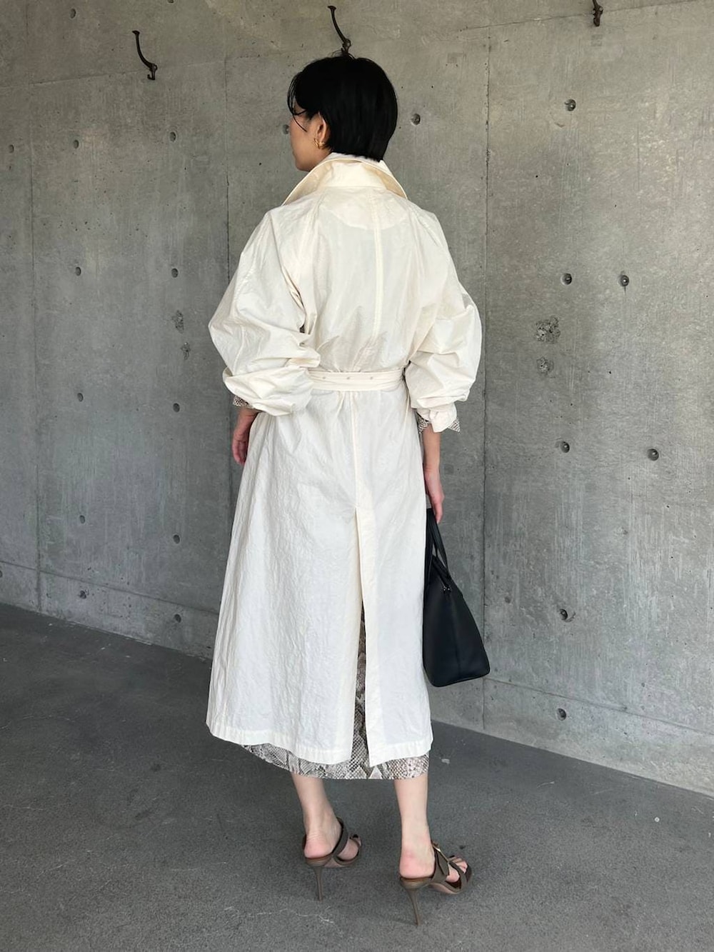 ホワイト系のステンカラーコート、ベージュ系のワンピースを着用したレディースの春コーディネートの4枚目の写真