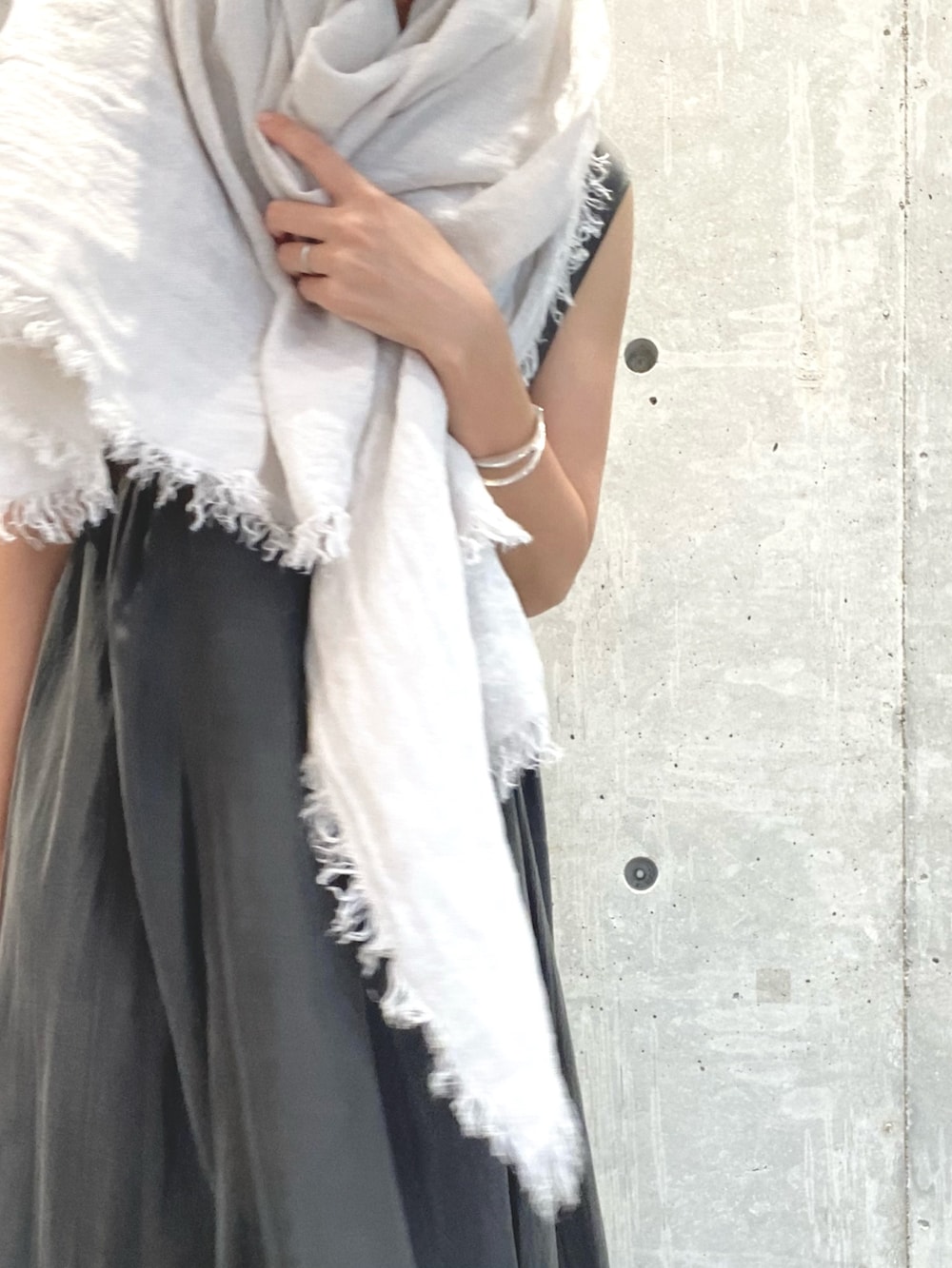 グレー系のワンピース、ベージュ系のサンダル、シルバー系のネックレスを着用したレディースの夏コーディネートの5枚目の写真