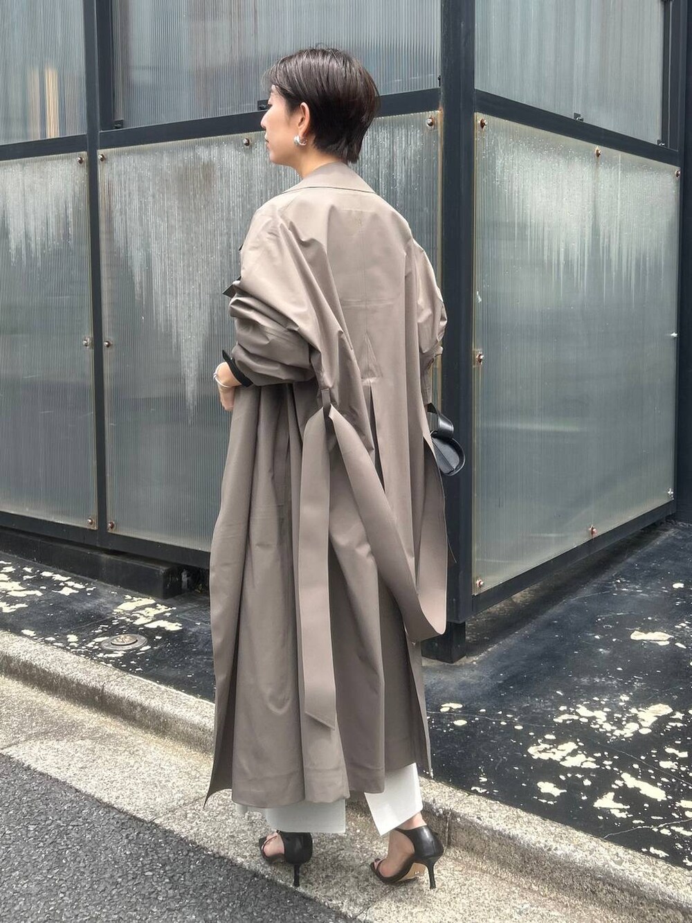 ベージュ系のシャツ/ブラウス、ブラウン系のトレンチコート、ブラック系のサンダルを着用したレディースの夏コーディネートの4枚目の写真