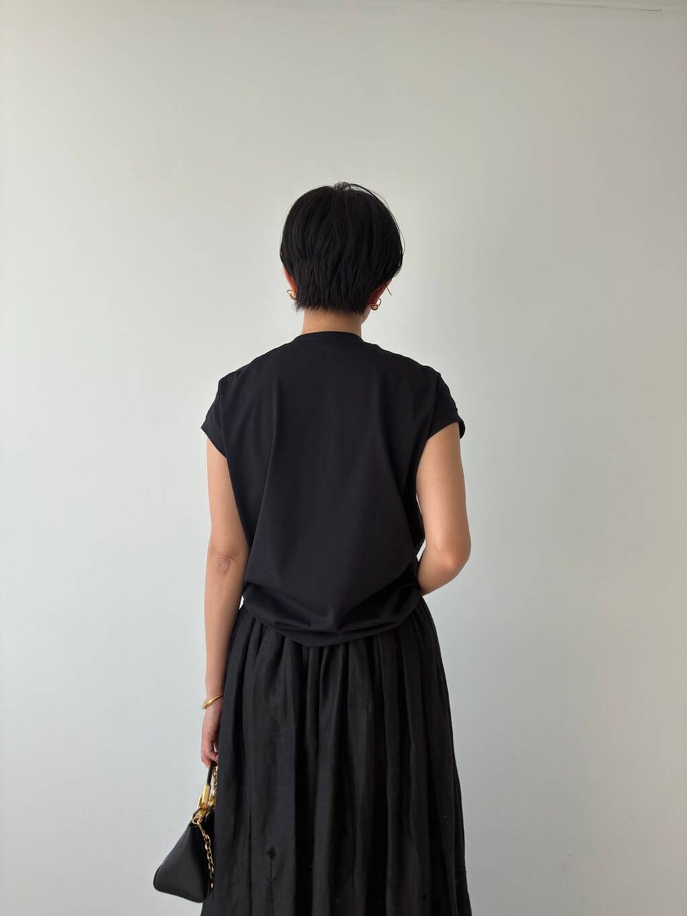 ブラック系のTシャツ/カットソー、ブラック系のスカートを着用したレディースの春コーディネートの7枚目の写真
