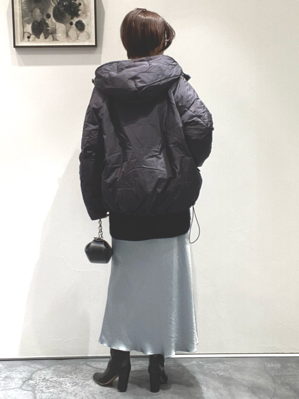 グリーン系のスカート、ブラック系のニット/セーター、グレー系のジャケット/アウターを着用したレディースの秋コーディネートの4枚目の写真