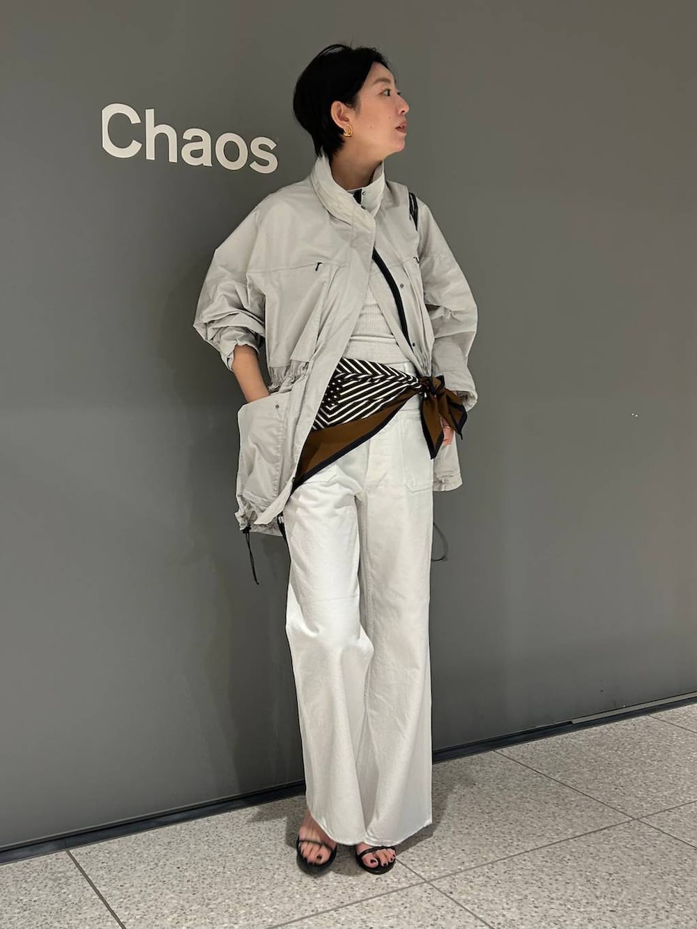 ホワイト系のデニムパンツ、ホワイト系のタンクトップ、グレー系のブルゾンを着用したレディースの春コーディネートの3枚目の写真