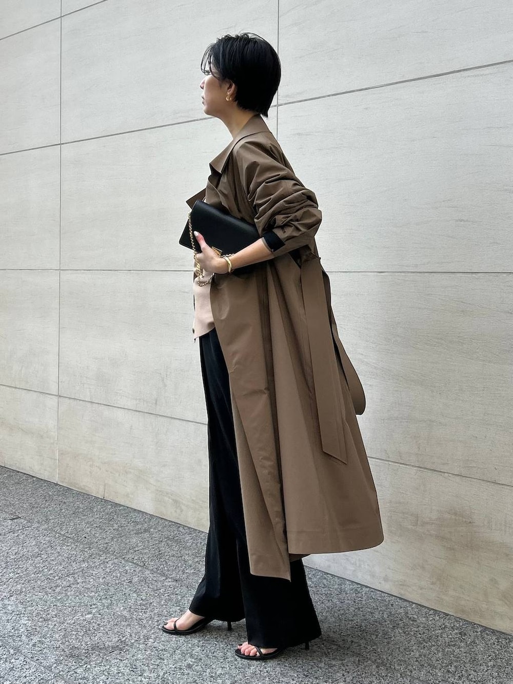 ブラック系のキャミソール、ブラック系のスラックス、ブラウン系のカーディガン/ボレロを着用したレディースの冬コーディネートの2枚目の写真