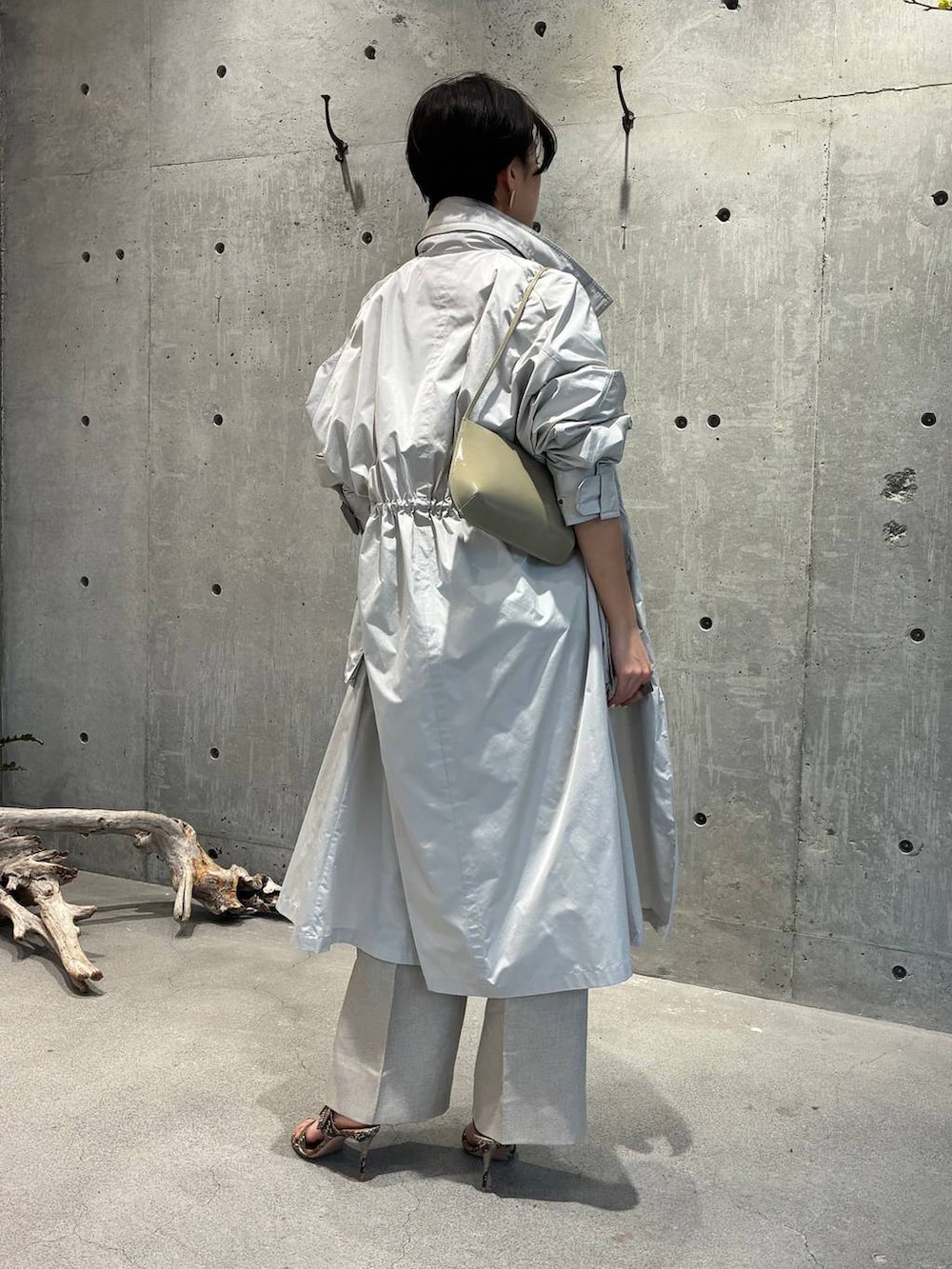 ホワイト系のスラックス、グレー系のナイロンジャケットを着用したレディースの春コーディネートの3枚目の写真