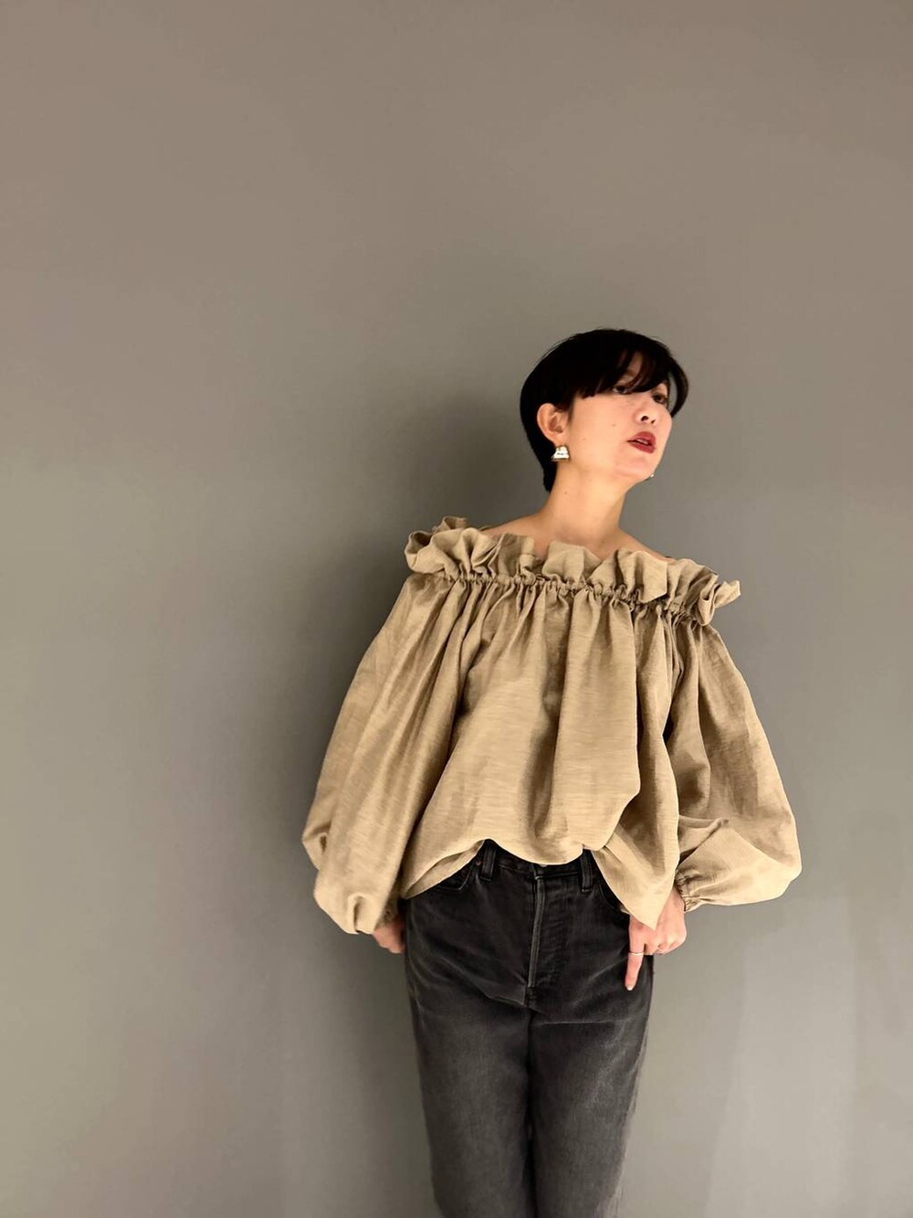 ブラック系のデニムパンツ、ベージュ系のシャツ/ブラウスを着用したレディースの冬コーディネートの2枚目の写真
