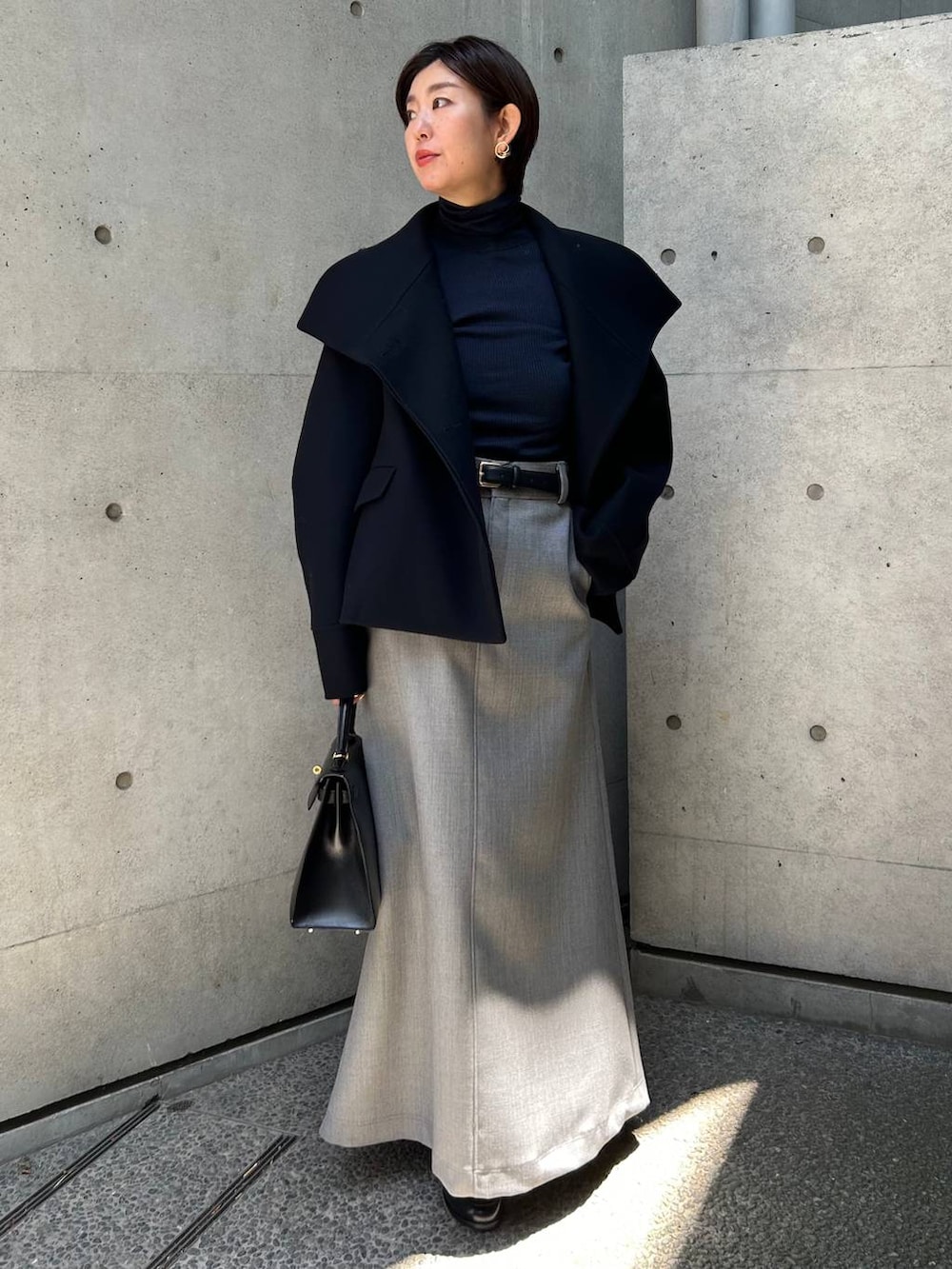 ブルー系のその他アウター、ブルー系のニット/セーター、グレー系のスカートを着用したレディースの秋コーディネートの8枚目の写真