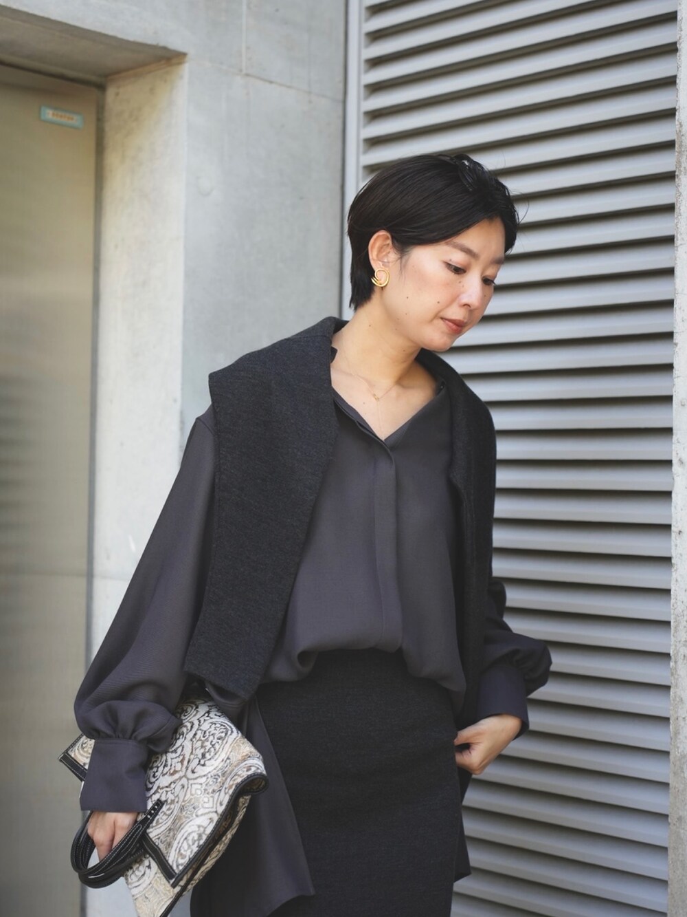 グレー系のシャツ/ブラウス、グレー系のスカート、グレー系のバッグを着用したレディースの秋コーディネートの3枚目の写真