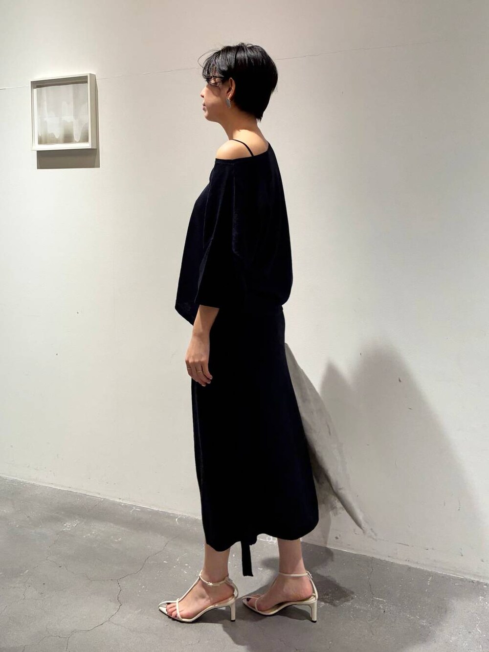 ブルー系のニット/セーター、ブルー系のスカート、グレー系のストール/ショールを着用したレディースの春コーディネートの2枚目の写真