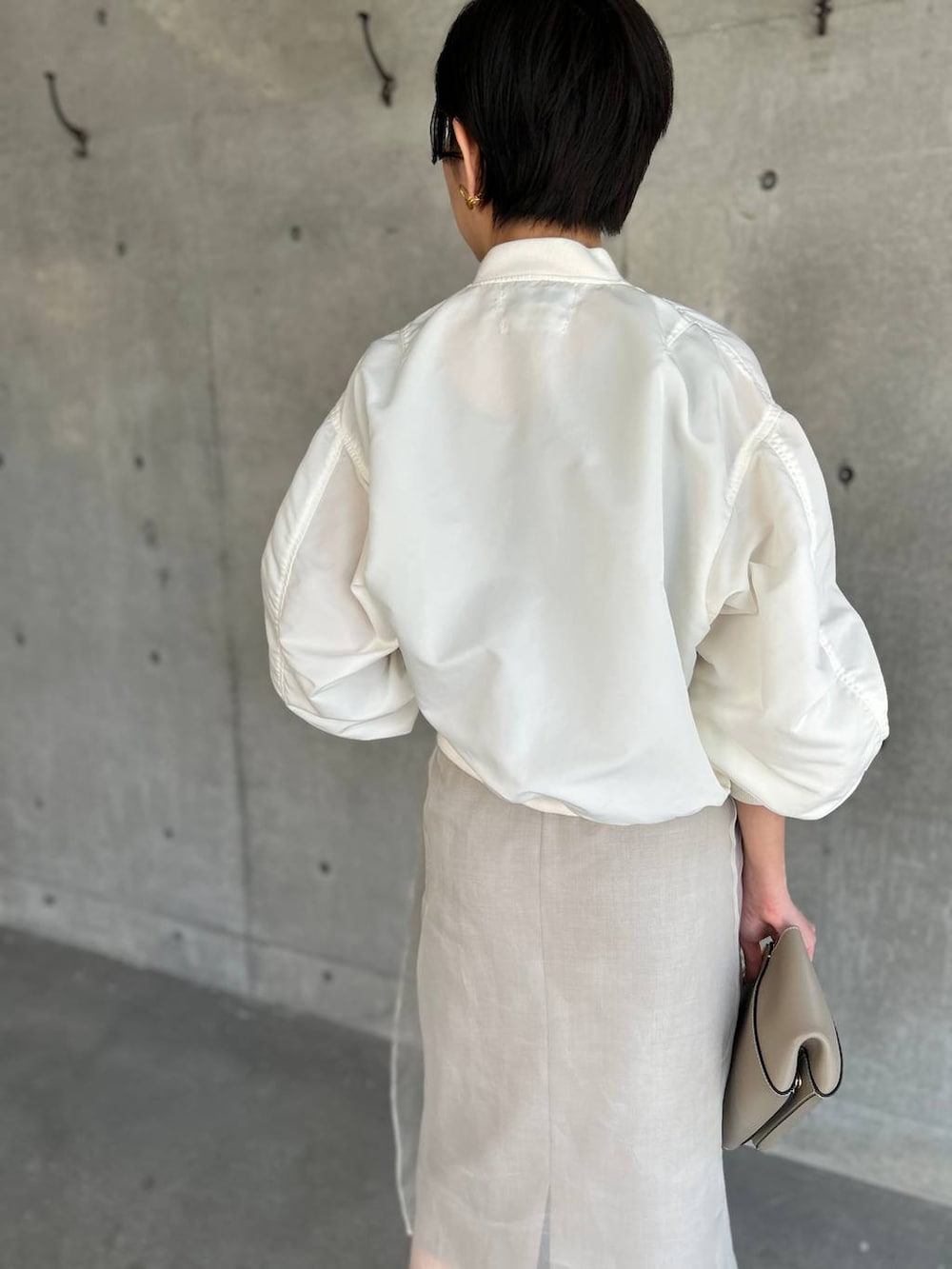 ベージュ系のスカート、ホワイト系のMA-1を着用したレディースの春コーディネートの7枚目の写真