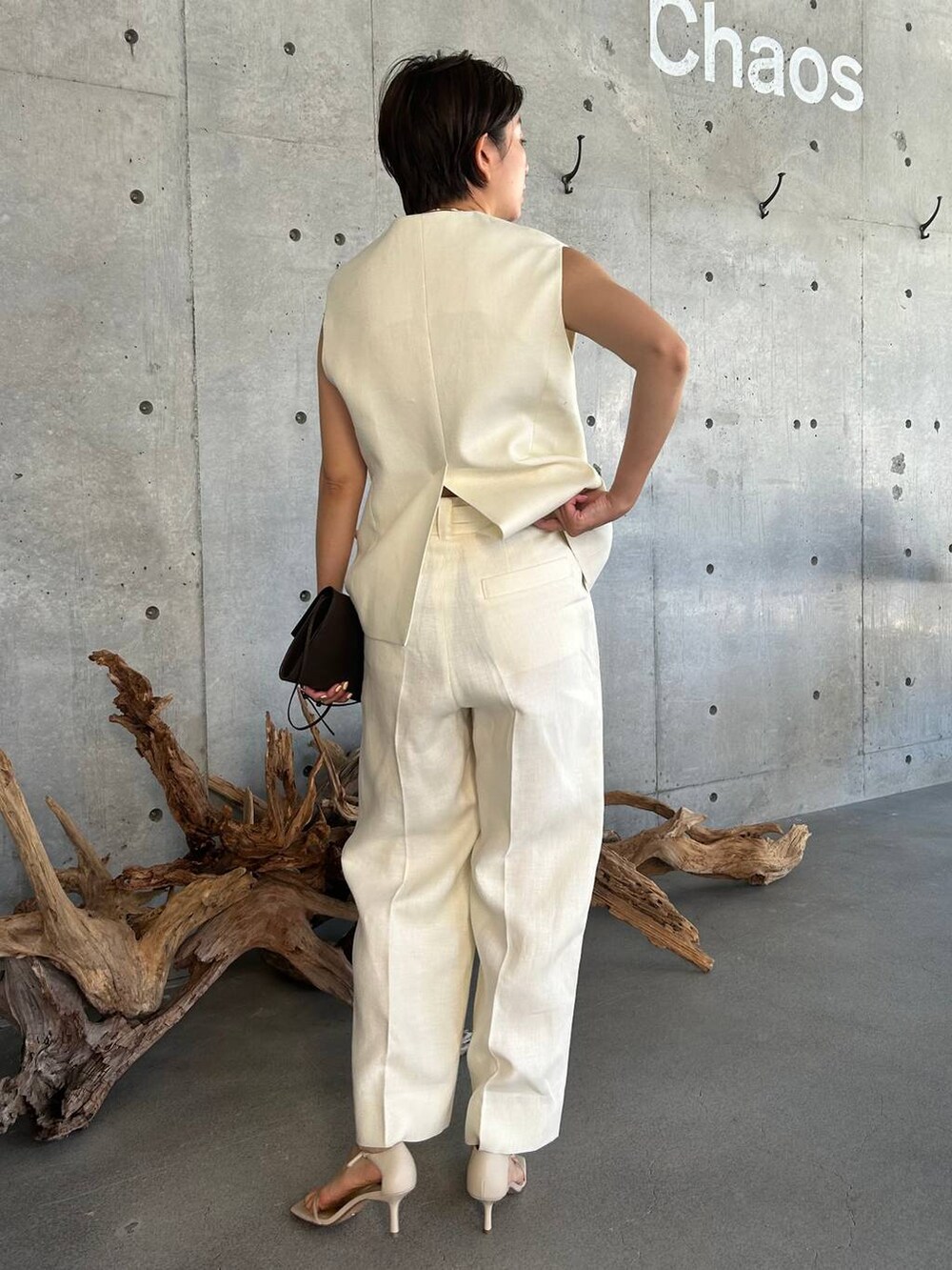 ブルー系のキャミソール、ベージュ系のサンダル、ホワイト系のスラックスを着用したレディースの夏コーディネートの4枚目の写真