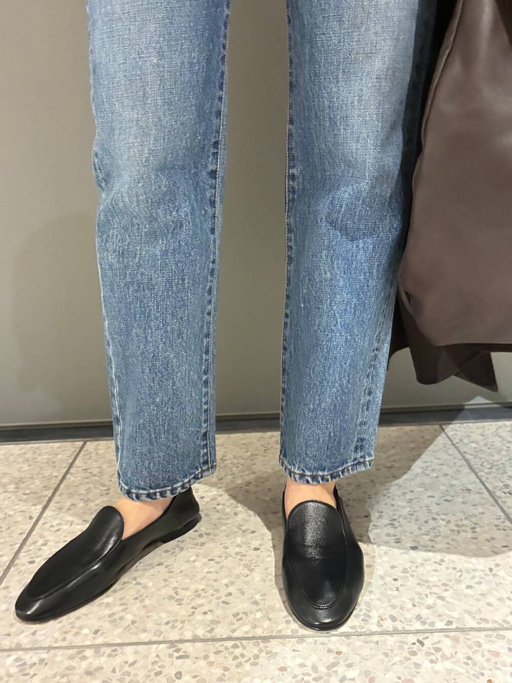 ブルー系のデニムパンツ、ブラウン系のニット/セーター、ブラウン系のノーカラーコートを着用したレディースの秋コーディネートの9枚目の写真