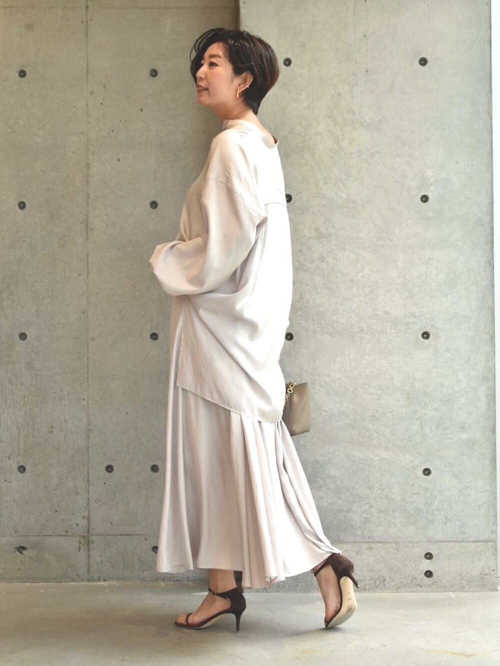 ベージュ系のシャツ/ブラウス、ベージュ系のスカート、ブラウン系のサンダルを着用したレディースの春コーディネートの2枚目の写真