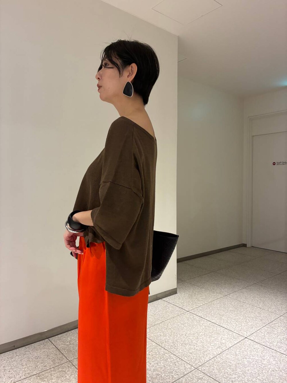 ブラウン系のニット/セーターを着用したレディースの春コーディネートの6枚目の写真