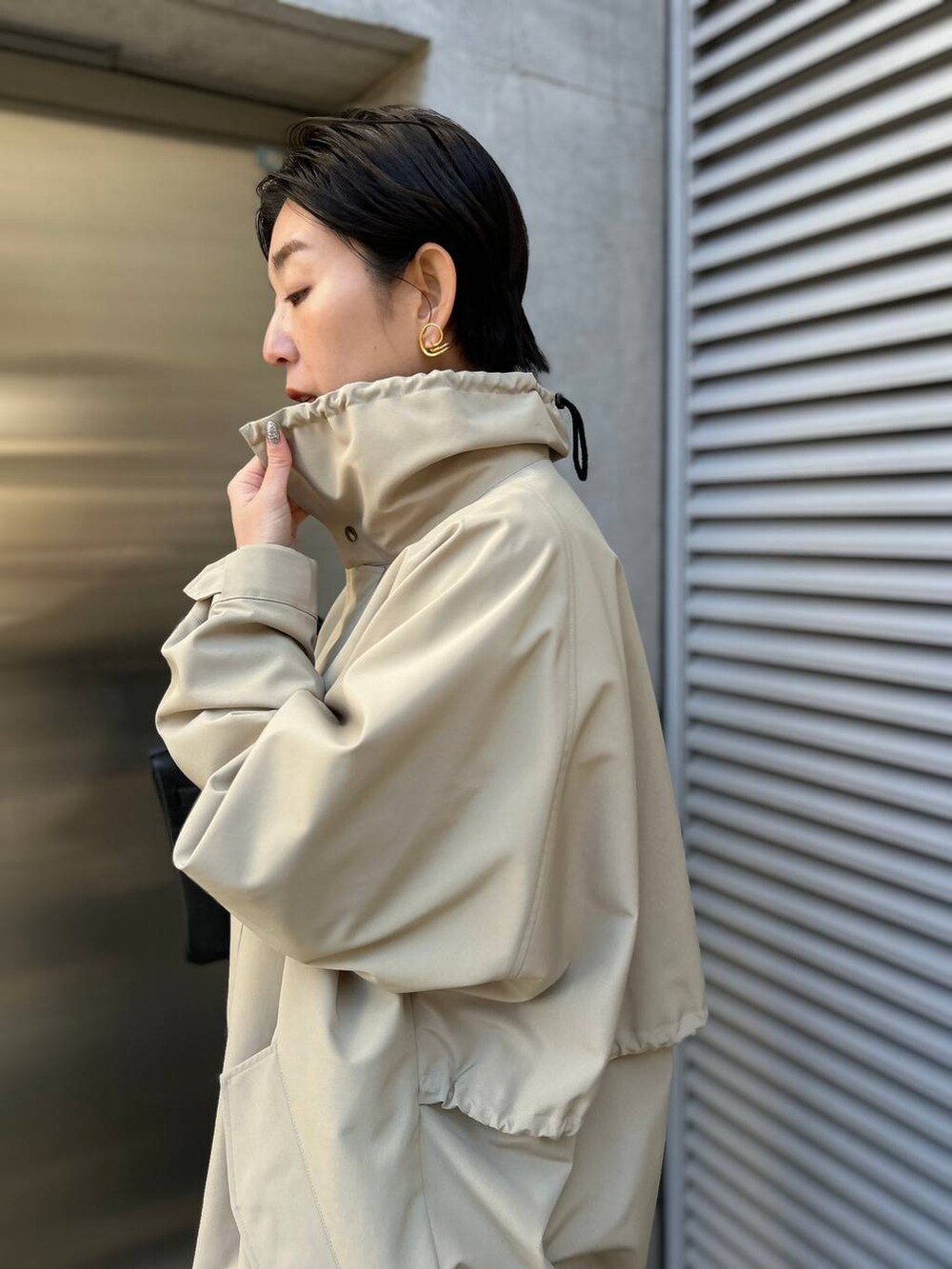 グレー系のニット/セーター、ブルー系のシャツ/ブラウス、グレー系のスラックスを着用したレディースの冬コーディネートの8枚目の写真