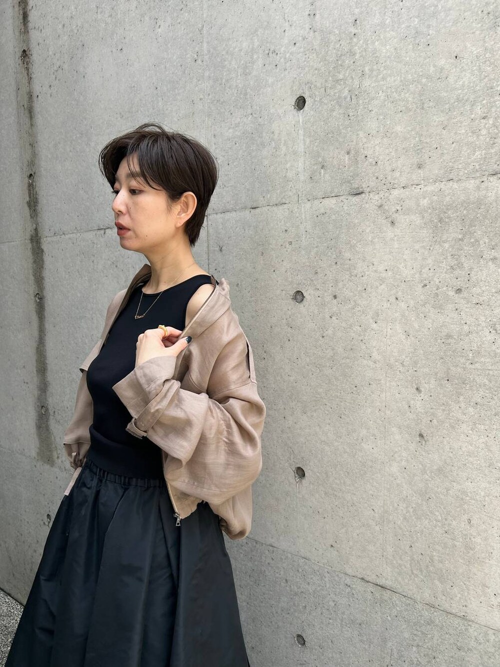 グレー系のブルゾン、ブラック系のスカート、ブラウン系のニット/セーターを着用したレディースの春コーディネートの7枚目の写真