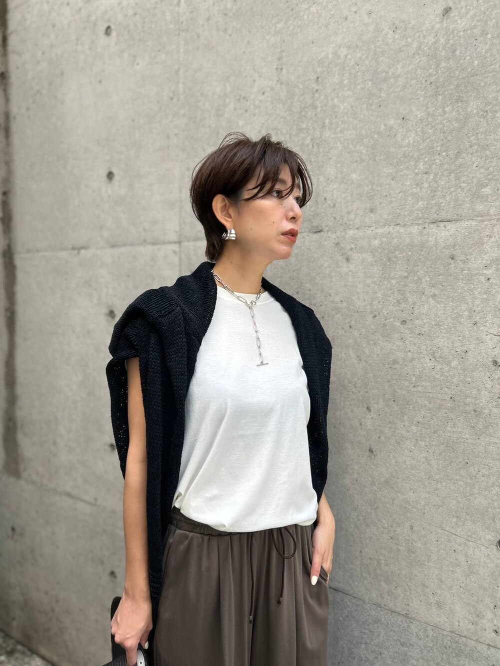 ホワイト系のTシャツ/カットソー、ブラック系のアンサンブル、ブラック系のサンダルを着用したレディースの春コーディネートの5枚目の写真