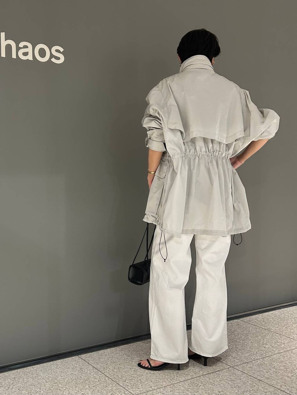 ホワイト系のデニムパンツ、ホワイト系のタンクトップ、グレー系のブルゾンを着用したレディースの春コーディネートの6枚目の写真