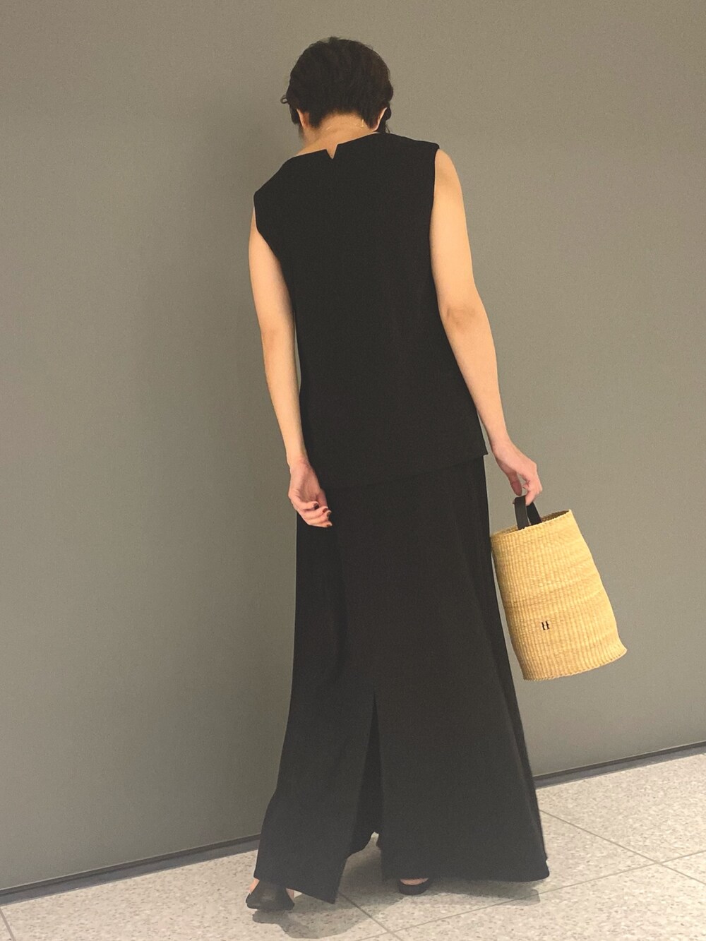 ブラック系のTシャツ/カットソー、ブラック系のスカート、ブラック系のサンダルを着用したレディースの春コーディネートの4枚目の写真