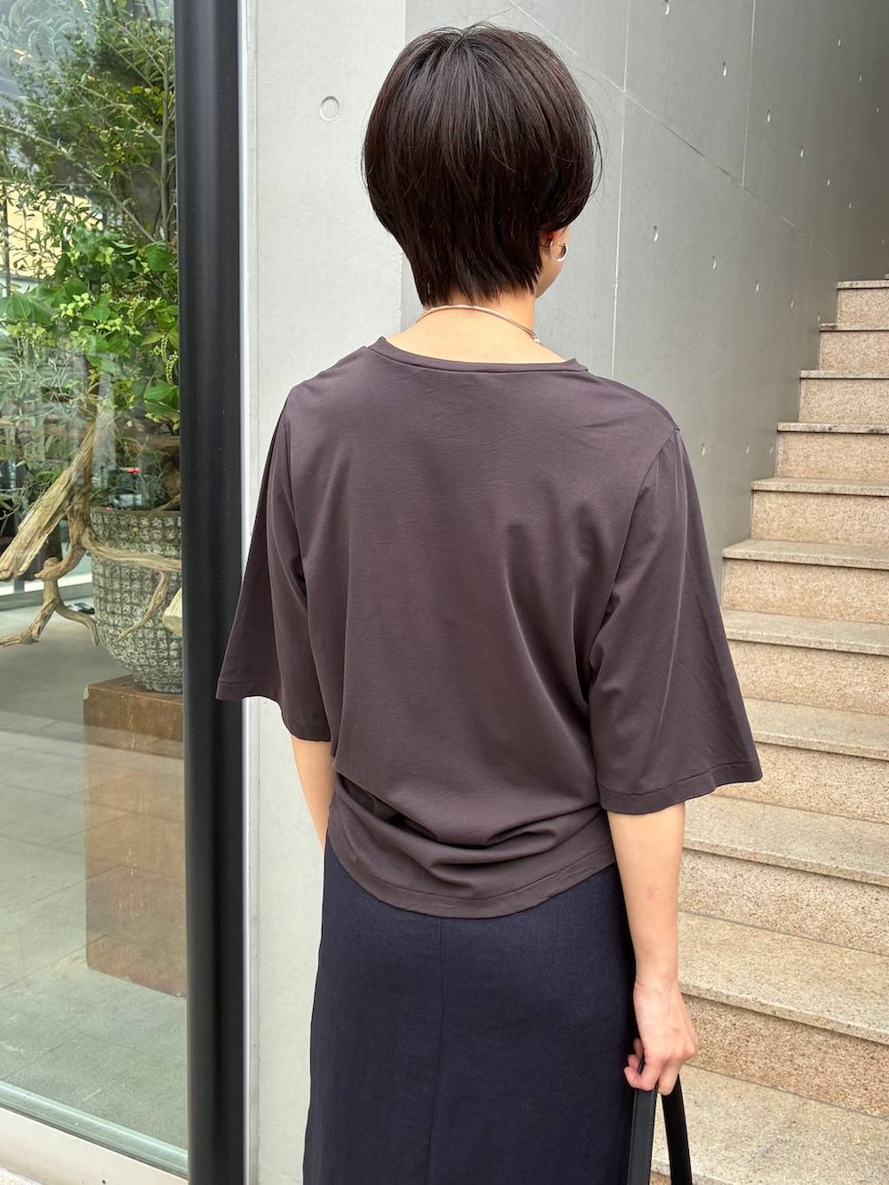 ブルー系のスカート、ブラック系のサンダル、ブラウン系のTシャツ/カットソーを着用したレディースの春コーディネートの6枚目の写真