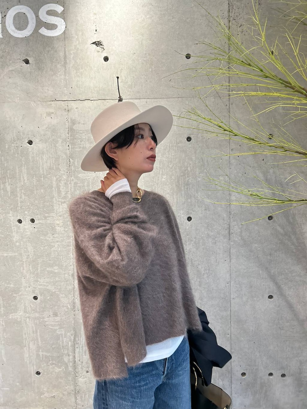 ブルー系のデニムパンツ、ブラウン系のニット/セーター、ホワイト系のTシャツ/カットソーを着用したレディースの秋コーディネートの4枚目の写真