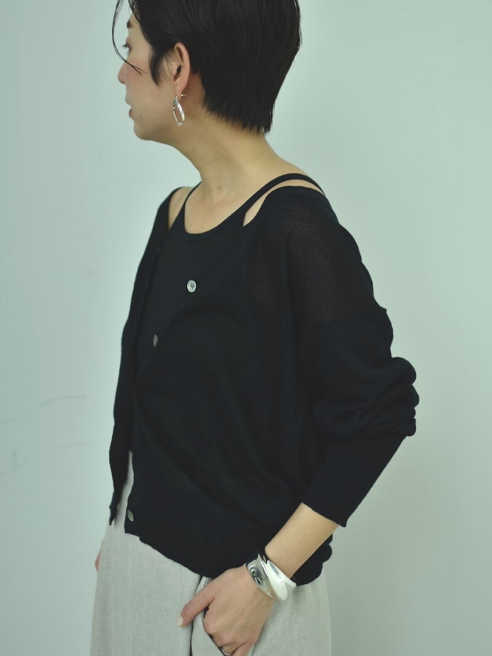 ブラック系のカーディガン/ボレロ、ブラック系のキャミソール、その他のスカートを着用したレディースの春コーディネートの4枚目の写真