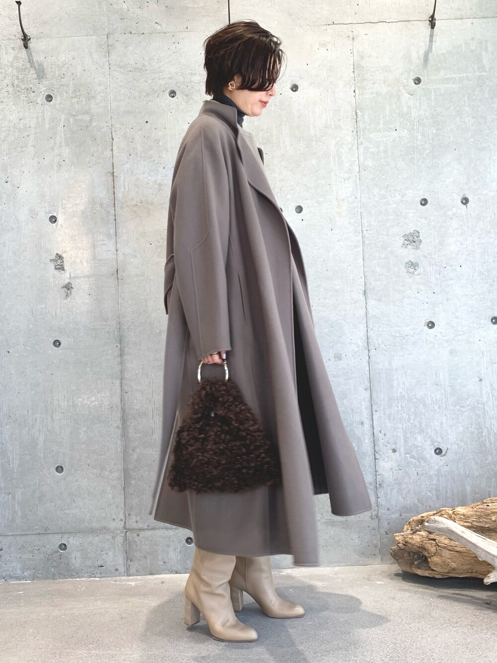 グレー系のニット/セーター、ベージュ系のトップス、ベージュ系のスカートを着用したレディースの秋コーディネートの2枚目の写真