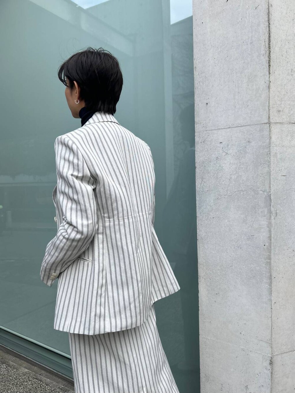 ブルー系のニット/セーター、ホワイト系のテーラードジャケット、ホワイト系のスカートを着用したレディースの冬コーディネートの7枚目の写真