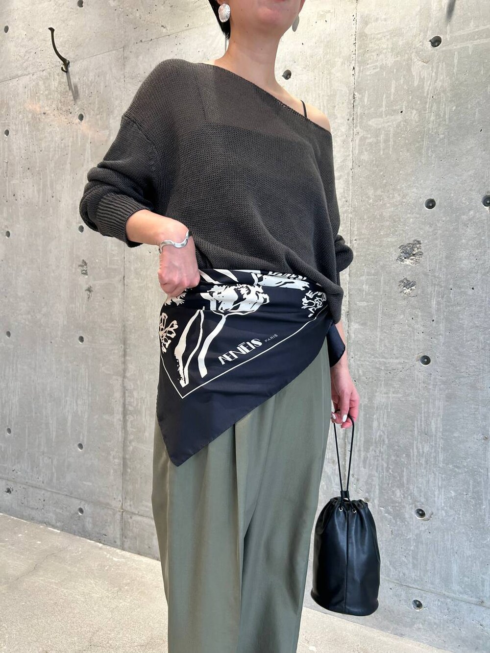 ブラック系のチューブトップ、グリーン系のニット/セーター、グリーン系のスラックスを着用したレディースの春コーディネートの6枚目の写真