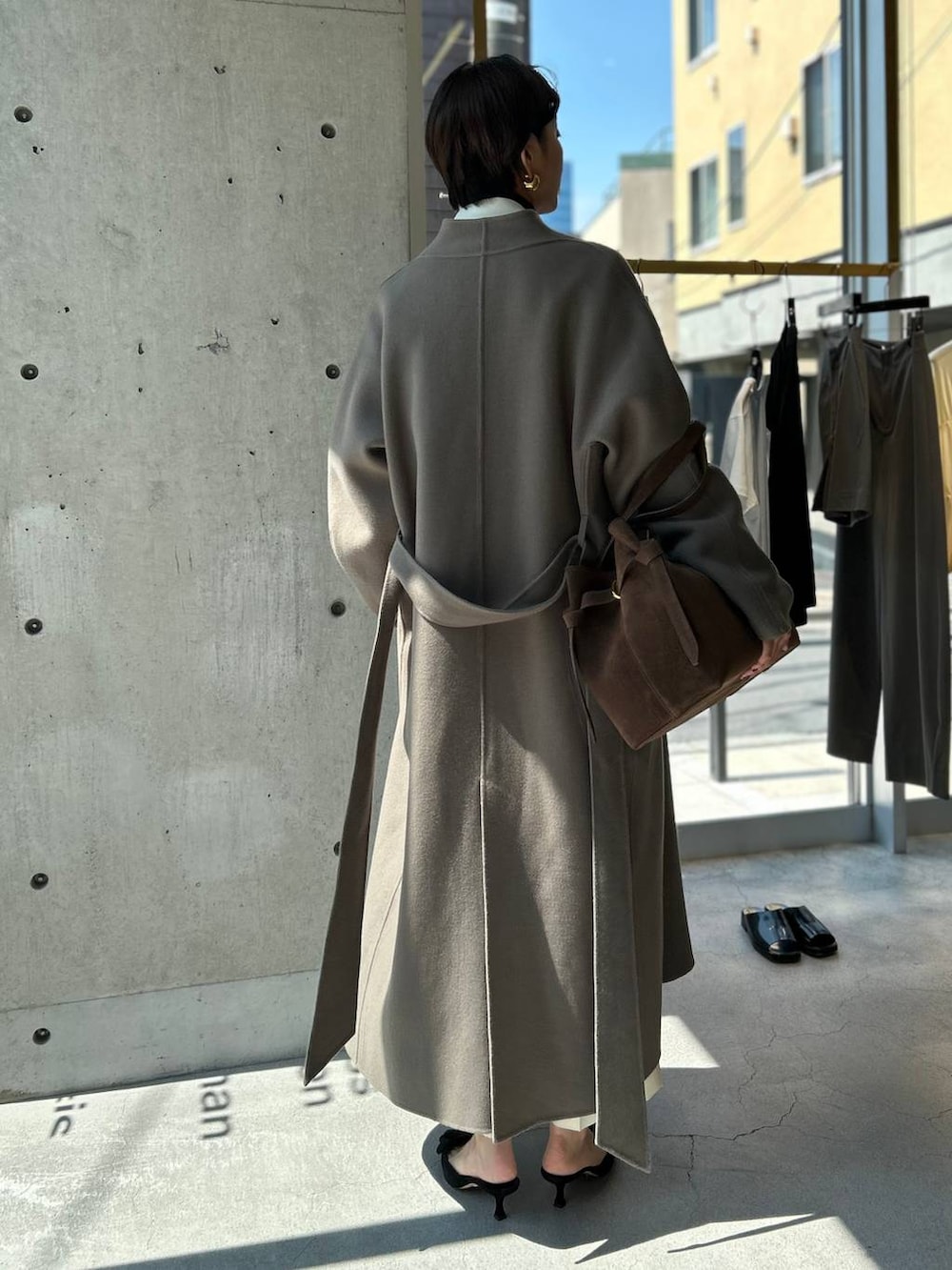 ブルー系のニット/セーター、ブラウン系のノーカラーコート、ホワイト系のテーラードジャケットを着用したレディースの秋コーディネートの9枚目の写真