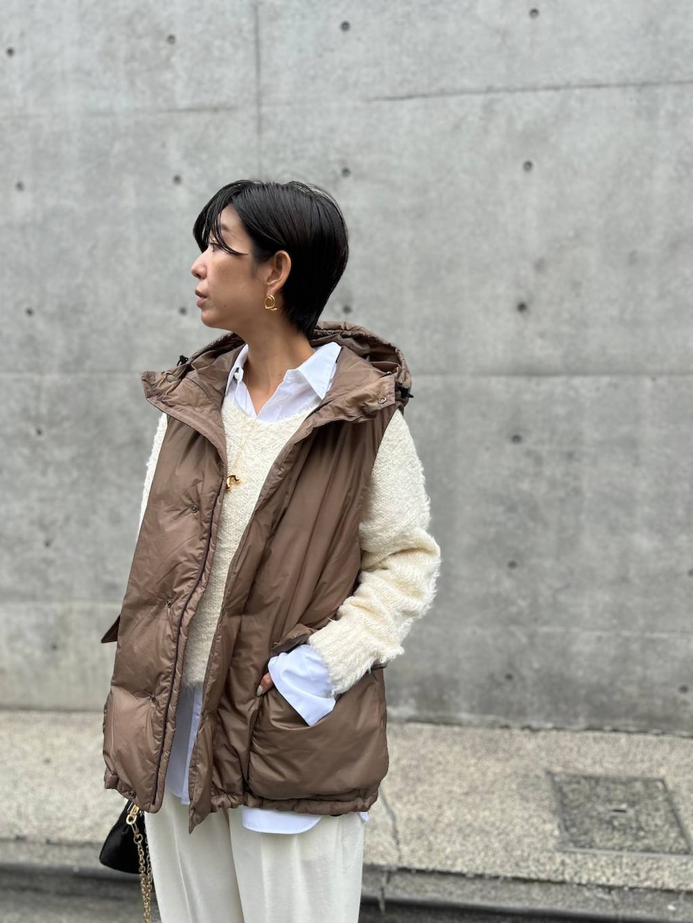 ホワイト系のシャツ/ブラウス、ホワイト系のニット/セーター、ホワイト系のスラックスを着用したレディースの秋コーディネートの4枚目の写真