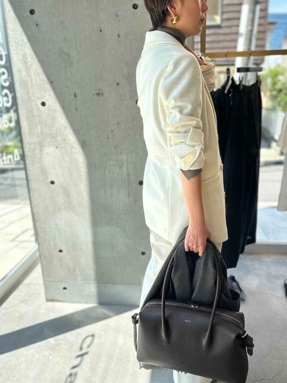 ベージュ系のニット/セーター、ホワイト系のスラックス、ホワイト系のテーラードジャケットを着用したレディースの秋コーディネートの5枚目の写真