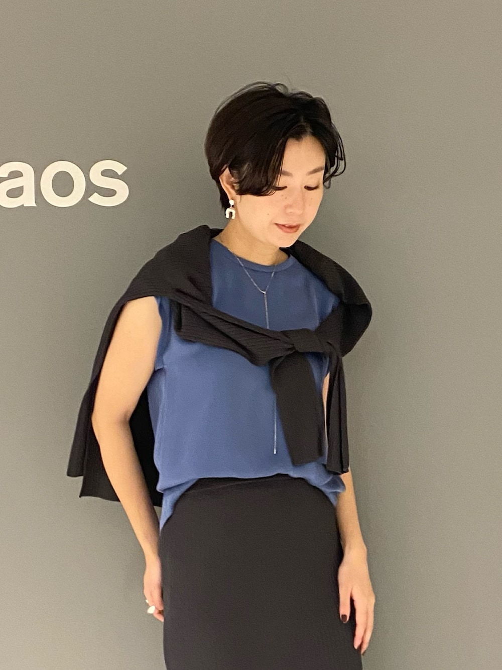 ブルー系のTシャツ/カットソー、ホワイト系のサンダル、グレー系のスカートを着用したレディースの夏コーディネートの5枚目の写真