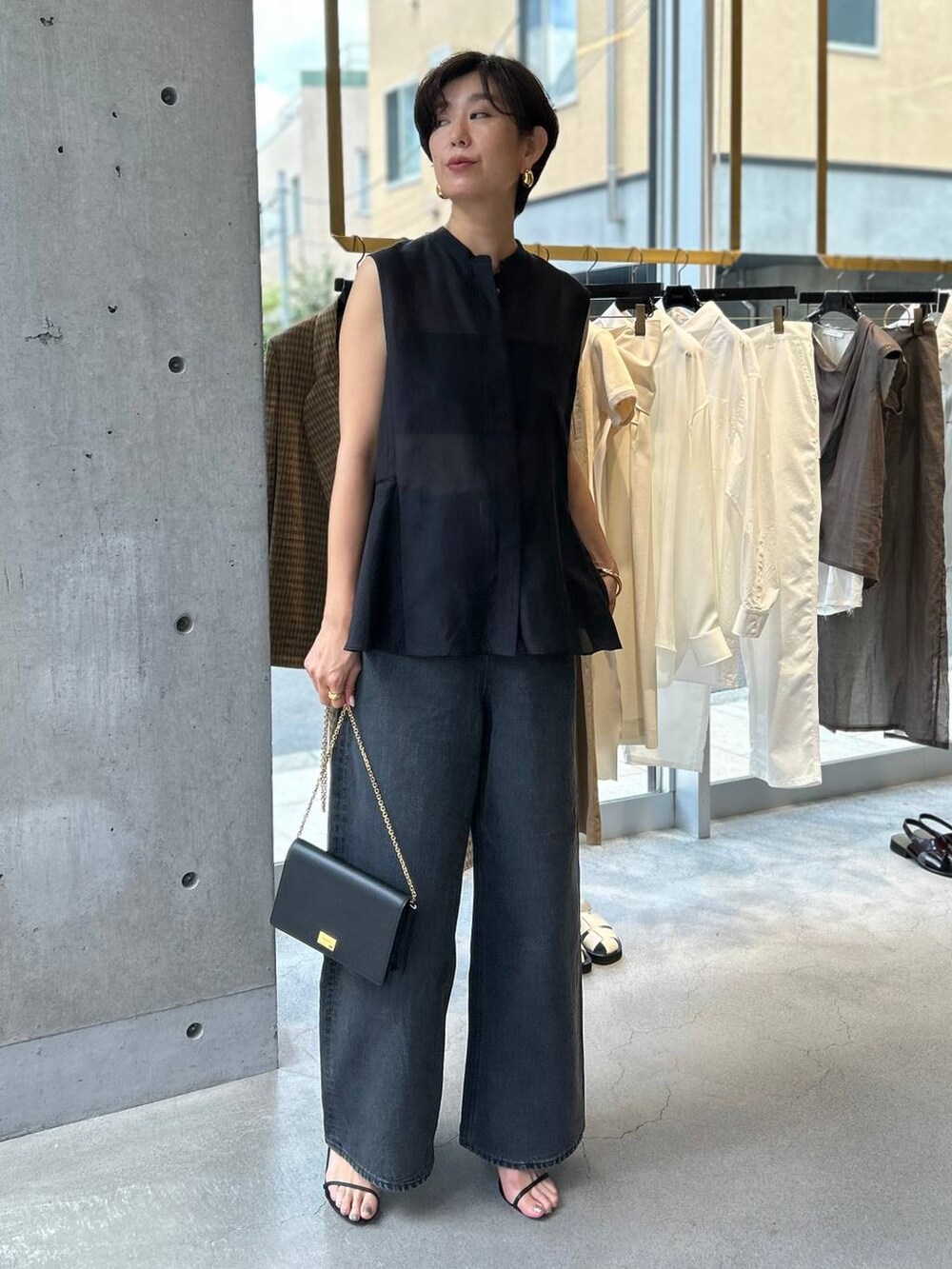 ブラック系のキャミソール、ブラック系のサンダル、ブラック系のデニムパンツを着用したレディースの夏コーディネートの2枚目の写真