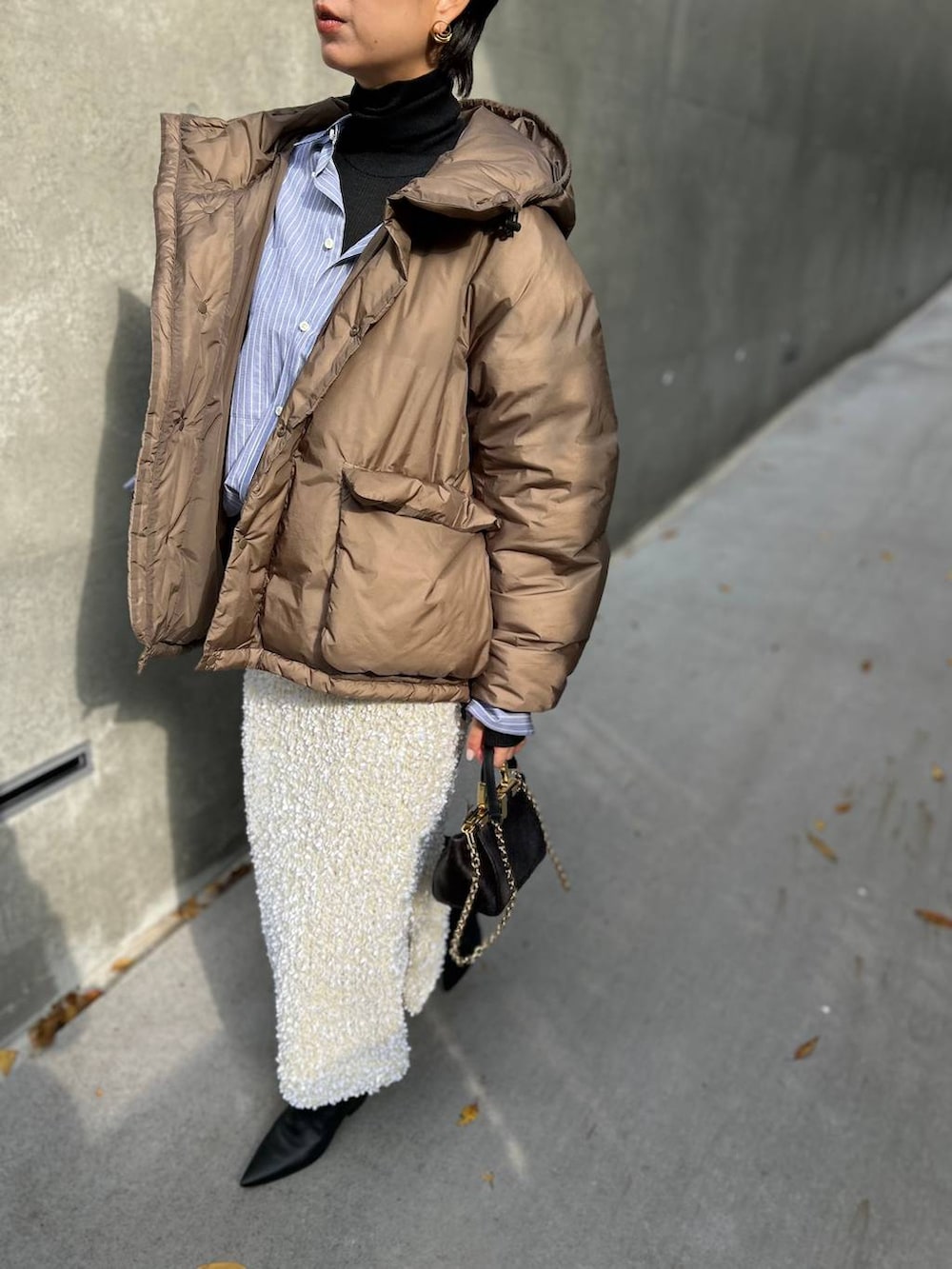 ブラック系のニット/セーター、ブルー系のシャツ/ブラウス、ブラウン系のダウンジャケット/コートを着用したレディースの冬コーディネートの7枚目の写真