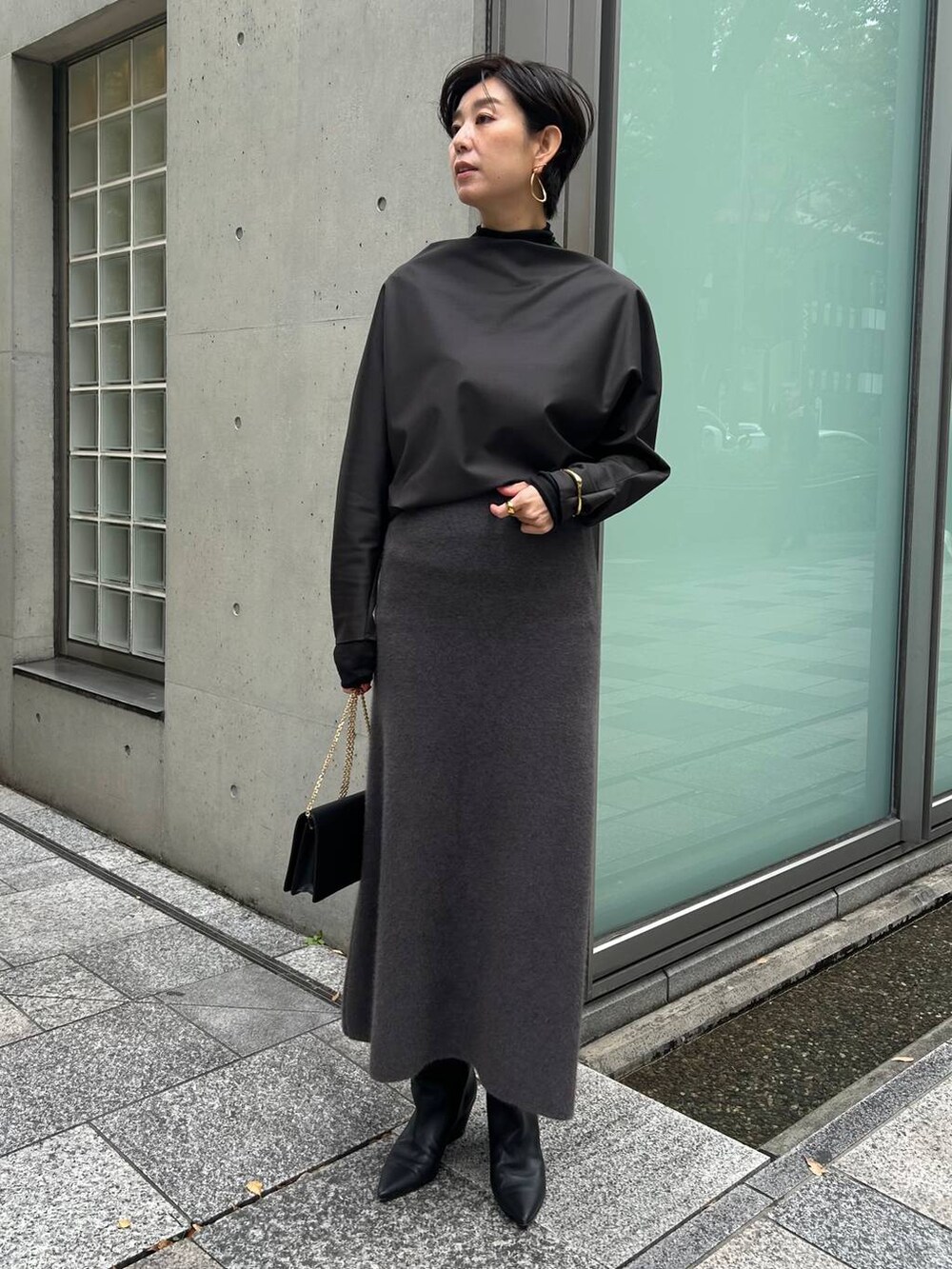 ブラック系のその他トップス、ブラック系のノーカラーコート、グレー系のスカートを着用したレディースの秋コーディネートの2枚目の写真